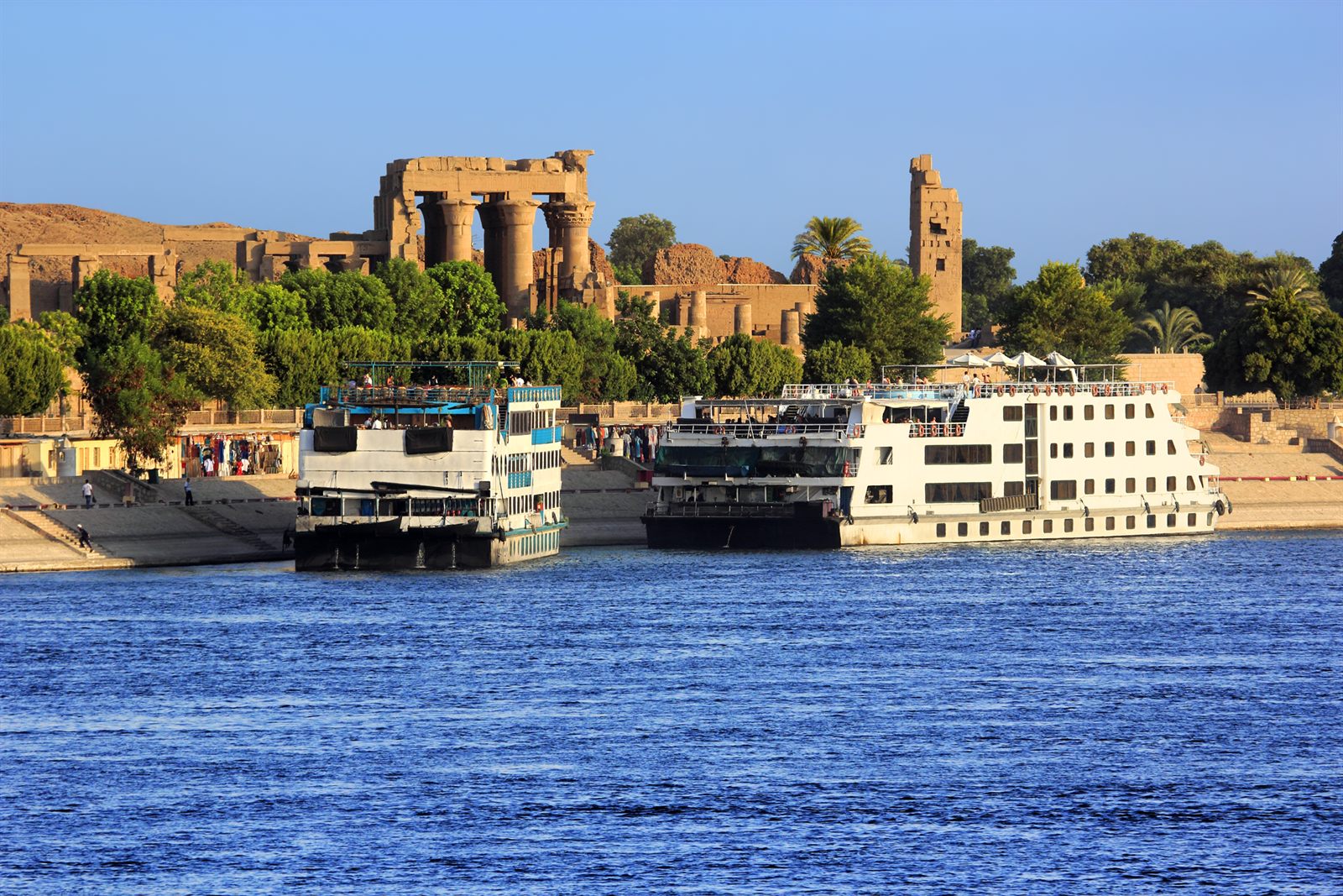 Egypt river cruise ships moored below the riverside temple of Kom Ombo on the Nile