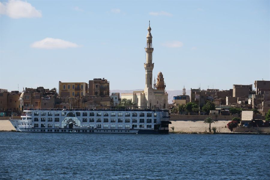 Nile cruise ship moored below a minaret on the riverbank