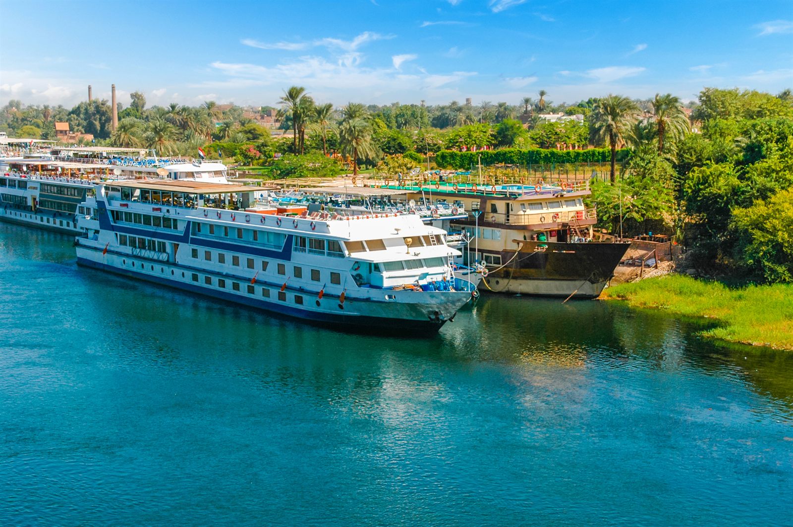 Nile cruise ships moored side by side on the riverbank, the classic Luxor to Aswan sailing